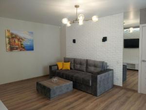 ein Wohnzimmer mit Sofa und Ziegelwand in der Unterkunft 2 room apartment in the center of Poltava in Poltawa