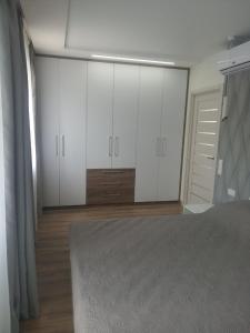 Schlafzimmer mit weißen Schränken und einem Bett in der Unterkunft 2 room apartment in the center of Poltava in Poltawa