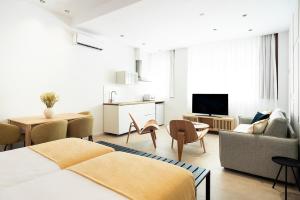 1 dormitorio con 2 camas y sala de estar en Blanq Marina Suites en Valencia