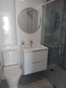 y baño con aseo, lavabo y ducha. en Apartamento Retama Golf I, en Chiclana de la Frontera