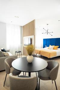 a living room with a bed and a table and chairs at Blanq Marina Suites in Valencia