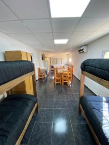 a room with bunk beds and a table and chairs at Cabañas Pausa Mendocina in San Rafael