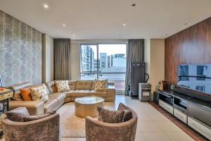 a living room with a couch and a tv at Luxury joy in Cape Town