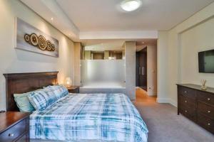 a bedroom with a bed and a dresser and a television at Luxury joy in Cape Town