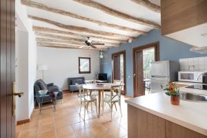 a kitchen and living room with a table and chairs at Can Morei in Orp&iacute;
