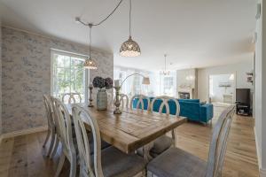 Villa de la Mer holiday home في Kaberneeme: غرفة طعام مع طاولة وكراسي خشبية