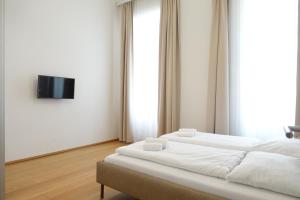 1 dormitorio con 2 camas y TV en la pared en Apartments 4 you Red Star 8, en Viena