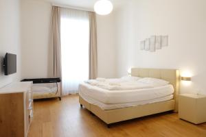 1 dormitorio blanco con 1 cama grande y TV en Apartments 4 you Red Star 8, en Viena