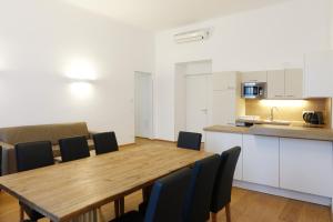 ein Esszimmer mit einem Tisch und Stühlen sowie eine Küche in der Unterkunft Apartments 4 you Red Star 8 in Wien