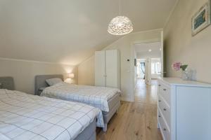 a bedroom with two beds and a white dresser at Villa de la Mer holiday home in Kaberneeme