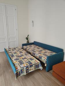 two beds in a room with a blue couch at Litseli in Athens