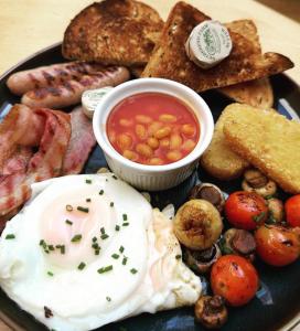 a plate of breakfast food with eggs bacon beans and toast at The Limes Hotel in Stratford-upon-Avon