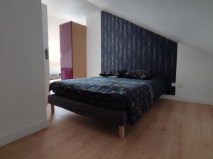 Schlafzimmer mit einem Bett mit einem schwarzen gepolsterten Kopfteil in der Unterkunft Le Clos du Parc Galamé in Loon-Plage