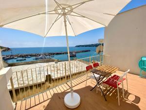 a balcony with a table and chairs and an umbrella at "La Terrazza" Corricella in Procida