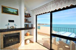 a living room with a fireplace and a view of the ocean at Jardins do Mar - BY BEDZY in Albufeira