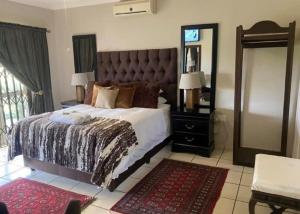 una camera con un grande letto e un grande specchio di Zacks Country Stay a Krugersdorp