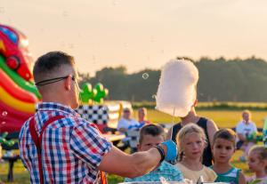 a man holding a popsicle in front of a group of children at Domki Letniskowe Biała Perła in Jezierzany +70 photos