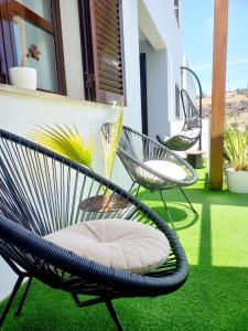 two chairs on a patio with green grass at Feliz Algarve in Albufeira