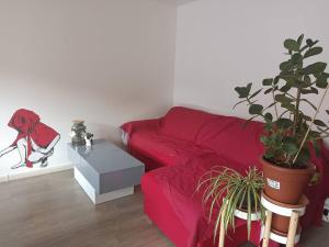 a living room with a red couch and potted plants at Appartement Street-art in Paris