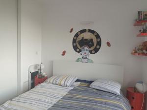 a bedroom with a bed with a clock on the wall at Appartement Street-art in Paris