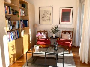 ein Wohnzimmer mit 2 Stühlen und einem Couchtisch in der Unterkunft Quiet Studio with garden 8 Min from Beach in Estoril