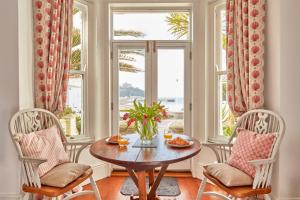 a dining room with a table and two chairs and a window at Ocean Villas in Marazion
