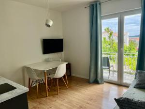 a living room with a table and chairs and a television at Apartment Udovičić in Vodice
