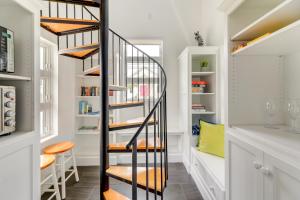 a spiral staircase in a home with white walls at Coastal North Carolina Abode - Rooftop Water Views in Morehead City