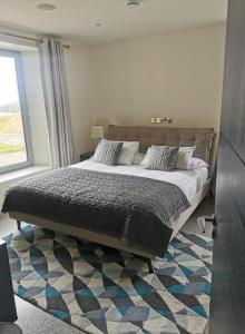 a large bed in a bedroom with a window at Seascapes in Inch