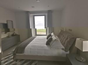 a bedroom with a large bed with a window at Seascapes in Inch