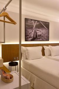 um quarto de hotel com uma cama e uma imagem de um moinho de vento em Tintto Hotel em Fortaleza