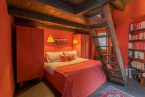 een slaapkamer met een oranje kamer met een stapelbed bij La Corte Degli Artisti by Rent All Como in Blevio