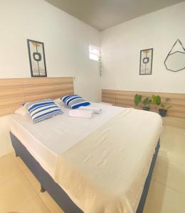 ジョアンペソアにあるPousada Sete Maresのベッドルーム(白と青の枕が備わる大きな白いベッド付)