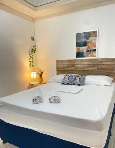 a large white bed with two towels on it at Pousada Sete Mares in João Pessoa