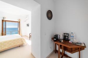 a bedroom with a bed and a table with a coffee maker at Castelo Guest House in Carvoeiro
