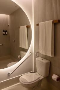 La salle de bains est pourvue de toilettes, d'une douche et de serviettes. dans l'établissement Tintto Hotel, à Fortaleza