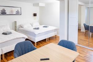 a room with two beds and a table and chairs at Apartments am Hauptbahnhof in Rostock
