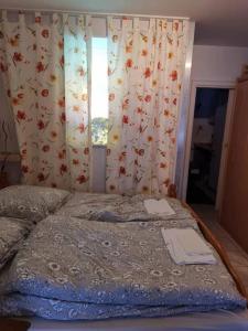 een slaapkamer met een bed en een raam met gordijnen bij FeWo-Mitten In Schwarzwald in Titisee-Neustadt