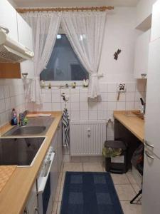 een kleine keuken met een wastafel en een raam bij FeWo-Mitten In Schwarzwald in Titisee-Neustadt