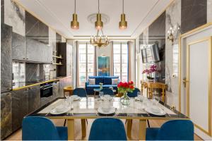 a dining room with a table and blue chairs at Luxury 3 bedroom 2 bathroom apartment - Louvre in Paris