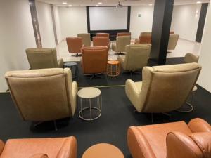 eine Gruppe von Stühlen und Tischen in einem Raum in der Unterkunft Park Veredas Flat Service in Rio Quente + 35 Fotos