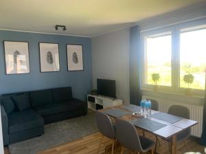 uma sala de estar com uma mesa e um sofá em IRS ROYAL APARTMENTS Apartamenty IRS Aviator em Gdansk