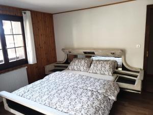 um quarto com uma cama e uma janela em Les Mélèzes em Val dʼIlliez