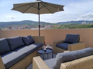 a patio with a couch and chairs and an umbrella at Casa Giuseppe Castelsardo in Castelsardo