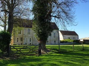 una casa grande con una valla delante en LA MAISON DE NACRE en Douvres-la-Délivrande