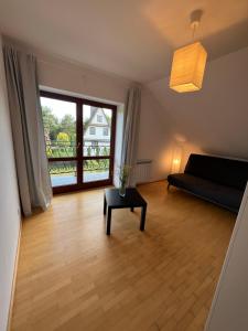 a living room with a couch and a table and a window at Dom pod klonami in Szczytno