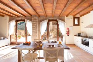 a kitchen with a wooden ceiling and a table and chairs at Can Morei in Orpí
