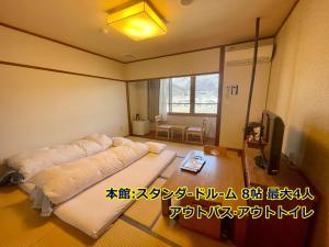 um quarto com uma cama e uma televisão em 湯布院 旅館 やまなみ Ryokan YAMANAMI em Yufu