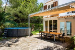 a patio with a table and a swimming pool at Sa Figuereta Beach in Playa de Muro