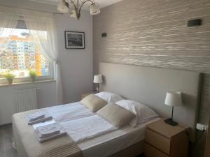 um quarto com uma grande cama branca e uma janela em IRS ROYAL APARTMENTS Apartamenty IRS Aviator em Gdansk